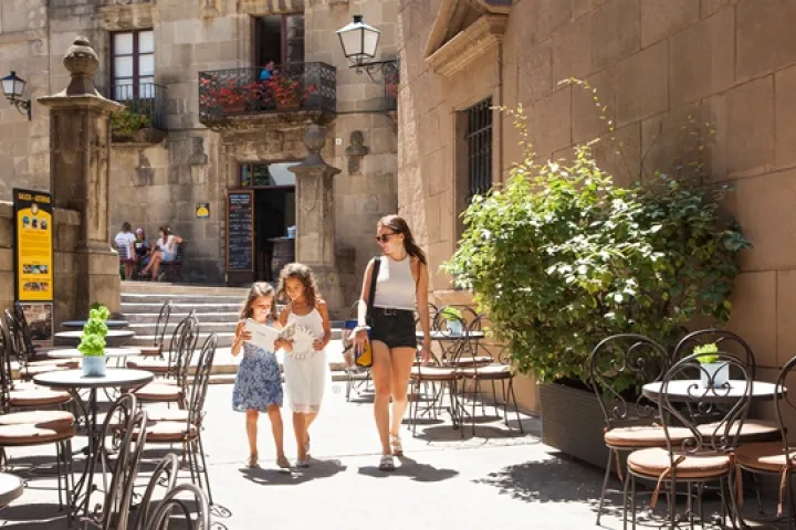 A family strolls between the terraces and façades of Poble Espanyol
