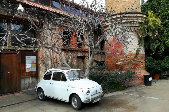La entrada cubierta de hiedra de Palo Alto, antigua fábrica del Poblenou convertida en espacio creativo, con un Fiat 500 aparcado delante