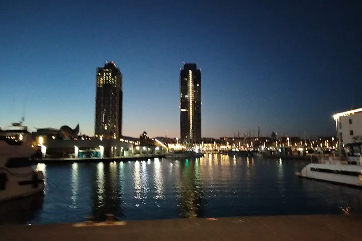 As duas torres do Port Olímpic, Hotel Arts e Torre Mapfre, refletindo-se na marina ao crepúsculo