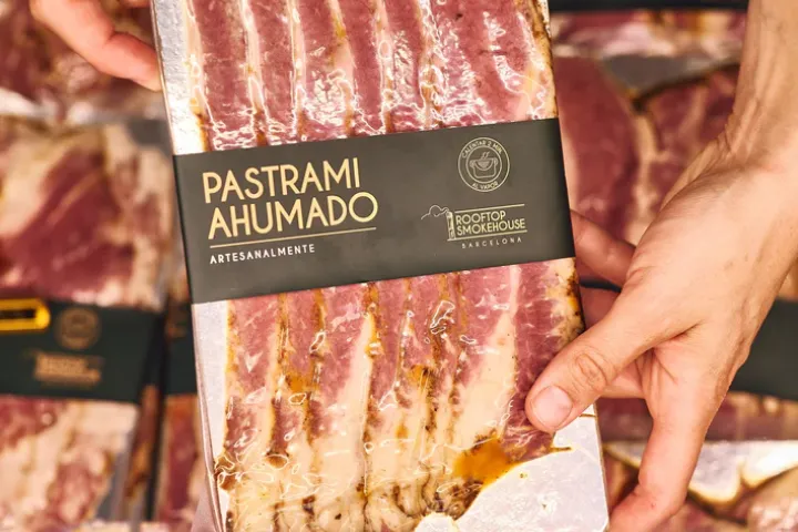 Paquete de pastrami ahumado de Rooftop Smokehouse presentado frente a otros productos.