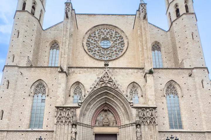 La fachada gótica de Santa María del Mar, su rosetón y sus dos torres octogonales bajo un cielo azul