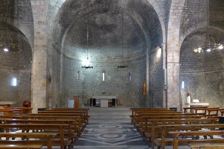 The nave of the church of Sant Pau del Camp towards the chancel and its three apses, with bare stone walls