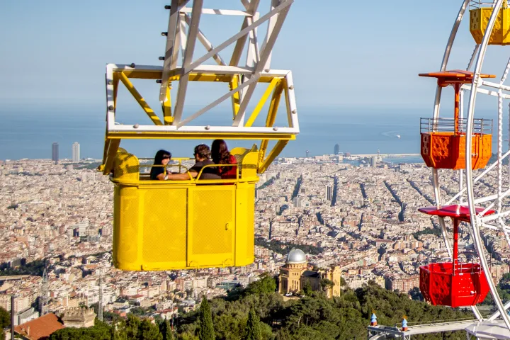 A gôndola amarela da Talaia elevada acima de Barcelona, ao lado das gôndolas da roda-gigante
