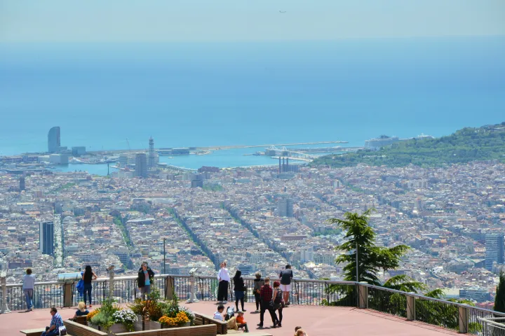 Visitantes no mirante do parque, de frente para Barcelona que se estende até o porto e o mar