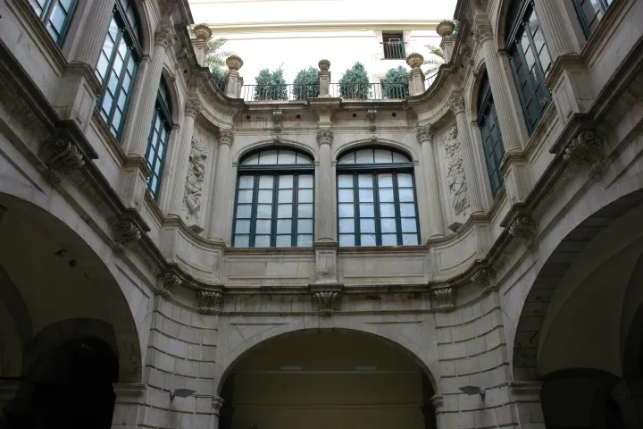 La cour intérieure du palais de la Virreina, ses arcades de pierre au rez-de-chaussée et la galerie vitrée de l'étage