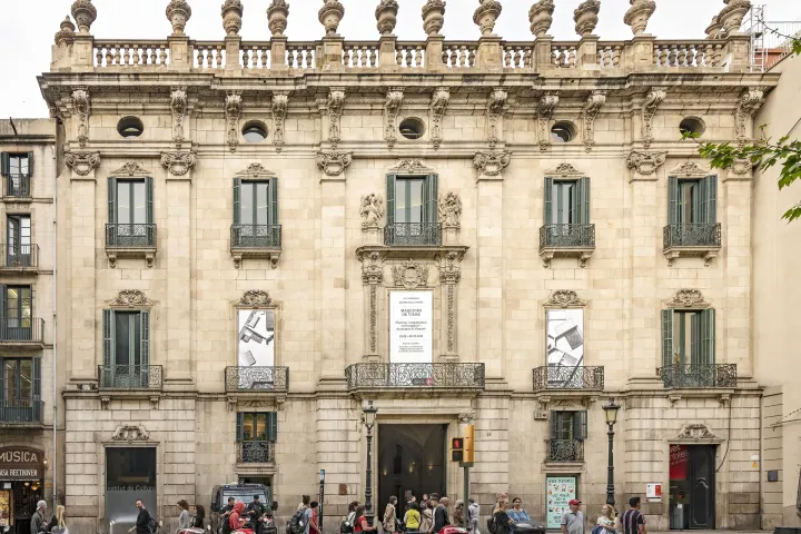 La façade du palais de la Virreina vue de face depuis la Rambla, ses balcons de fer forgé et sa balustrade sommée de vases