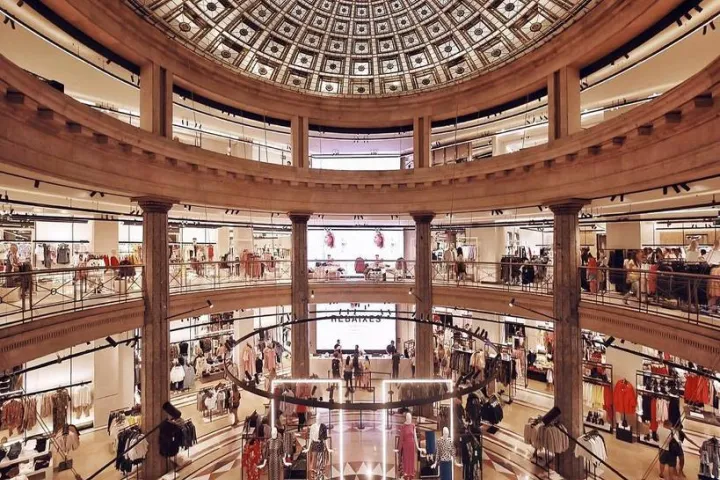 Interior de la tienda Zara en Plaça de Catalunya, bajo una gran cúpula de vidrio.