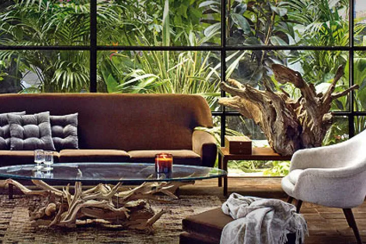 Salón decorado con muebles y accesorios de Zara Home frente a un ventanal.