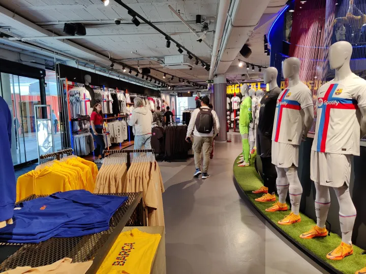 Ein Gang im Barça Store, gesäumt von Kleidung und Schaufensterpuppen, die die Vereinskleidung tragen.