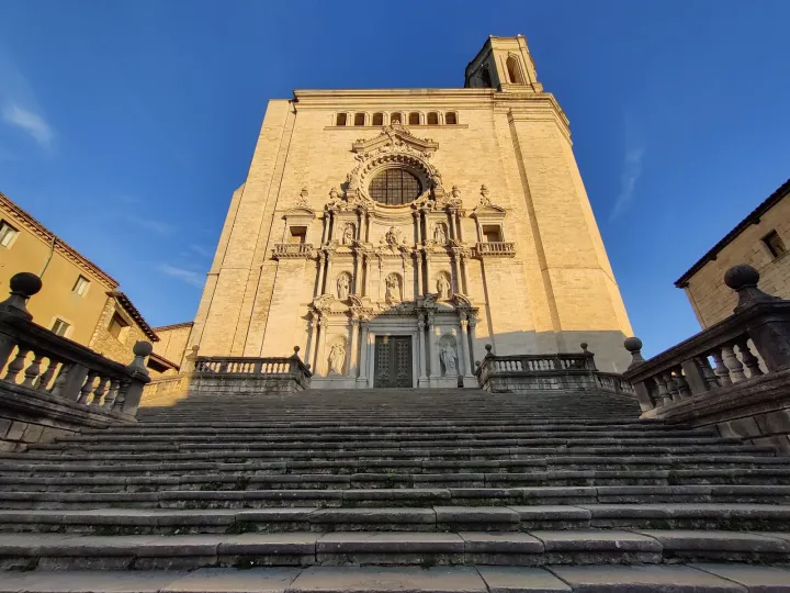 Eine breite Steintreppe führt zur barocken Fassade der Kathedrale, unter einem blauen Himmel.