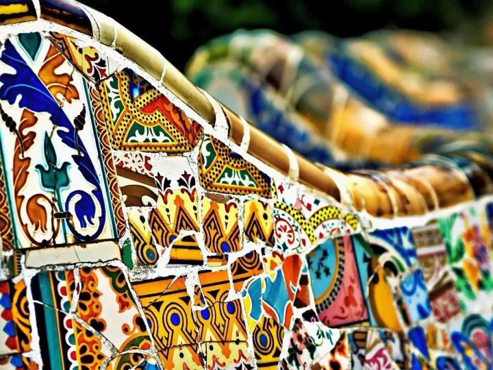 Gros plan sur le trencadís du banc ondulé du Parc Güell, fragments de céramique colorés