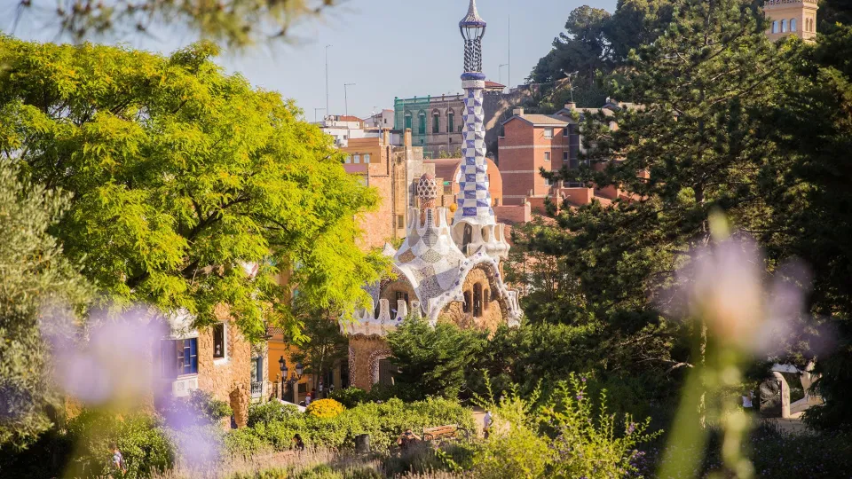 Il padiglione d'ingresso del Parc Güell e la sua guglia a mosaico, visti dai giardini