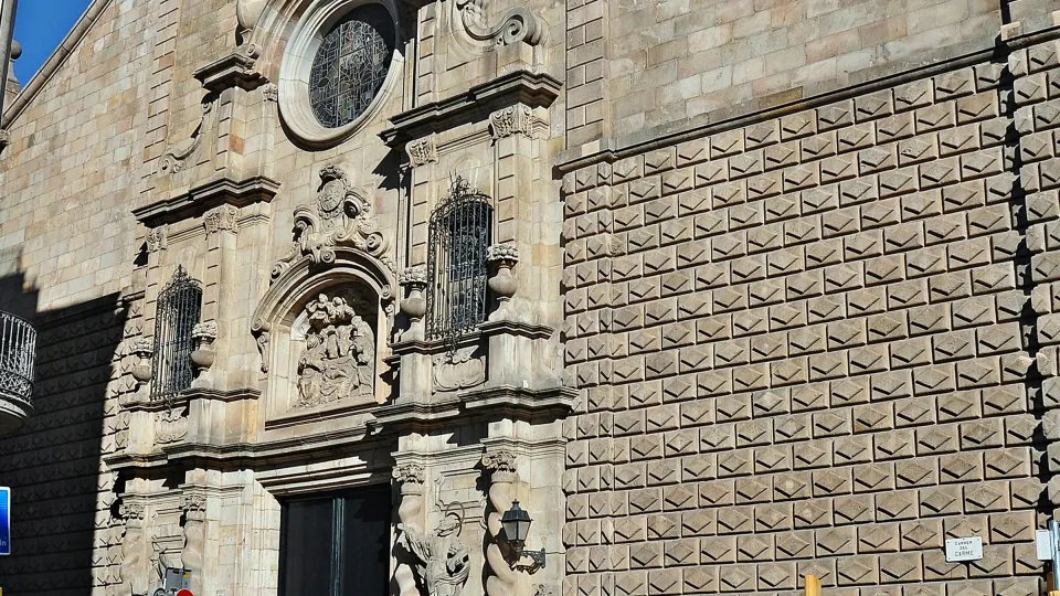 La facciata barocca della chiesa di Betlem all'angolo tra la Rambla e il carrer del Carme, sotto un cielo azzurro