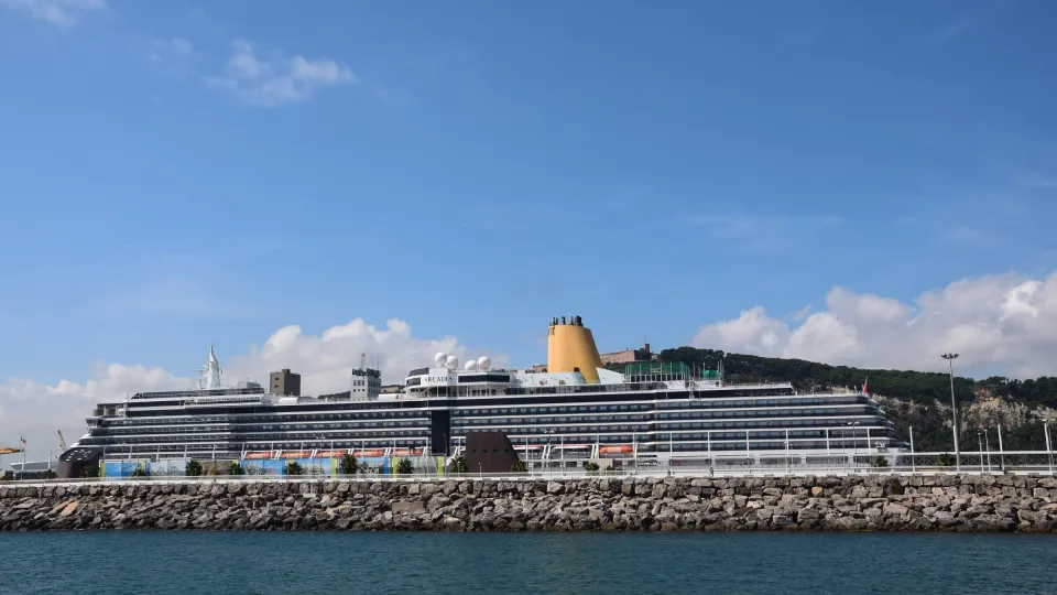 Una nave da crociera attraccata al Moll Adossat, con la collina di Montjuïc e il suo castello sullo sfondo