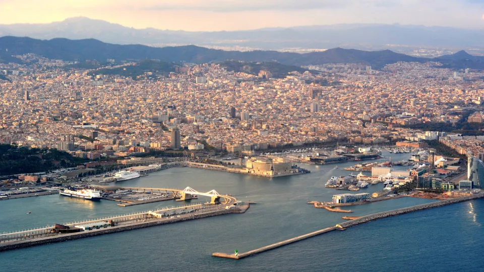 Port Vell visto do céu na luz do entardecer: o Moll d'Espanya, a Rambla de Mar, a marina e a cidade ao fundo