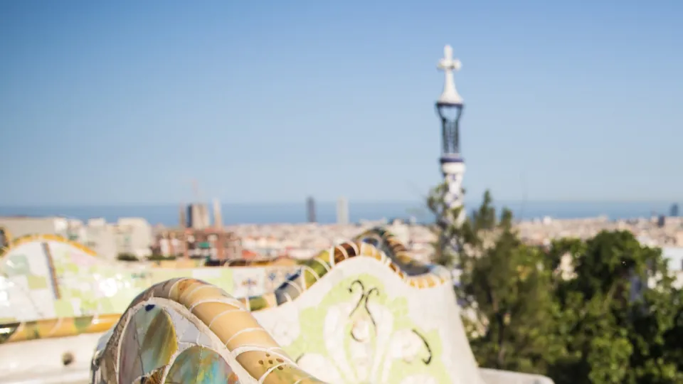 The mosaic bench on the main terrace of Park Güell, with Barcelona and the Sagrada Família beyond