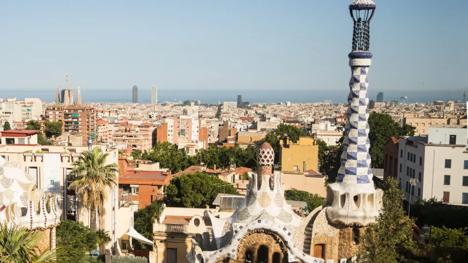 Os pavilhões da entrada do Parque Güell e Barcelona até o mar