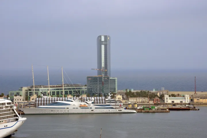 Vários navios de cruzeiro atracados no porto de Barcelona, vistos de Montjuïc, com a torre do hotel ao fundo