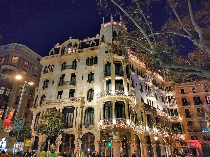 La facciata modernista della Casa Fuster illuminata di notte, in cima al Passeig de Gràcia, all'ingresso di Gràcia