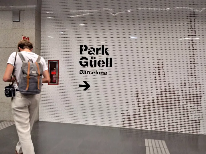 Dans la station de métro Lesseps, un panneau « Park Güell » indique la sortie vers le parc à un voyageur